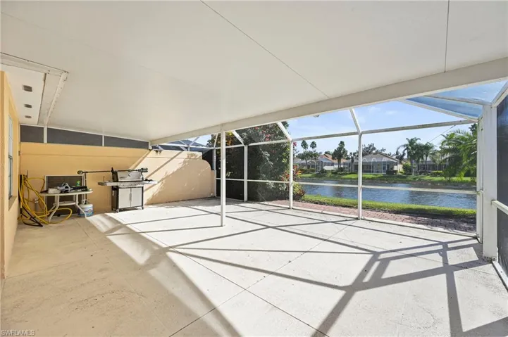Unfurnished sunroom featuring a water view and a patio