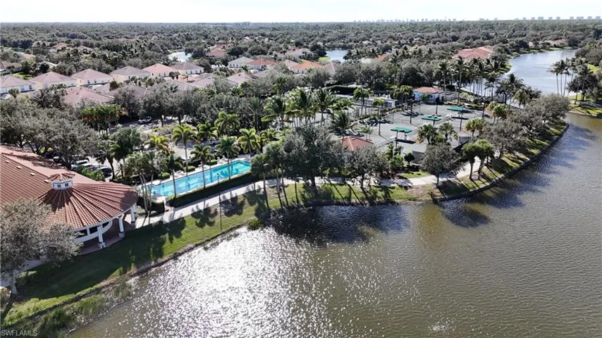 Aerial perspective of suburban area with a nearby body of water and a pool