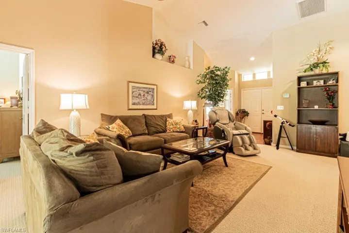 Living room featuring light carpet, high vaulted ceiling, and recessed lighting