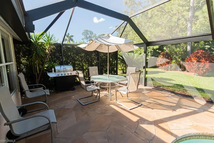 View of patio / terrace featuring glass enclosure, a grill, a sunroom, and outdoor dining space