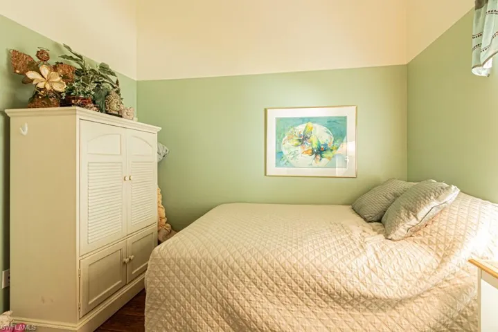 Bedroom with dark wood-type flooring and baseboards
