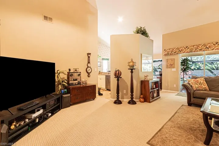 Living room with high vaulted ceiling and carpet floors