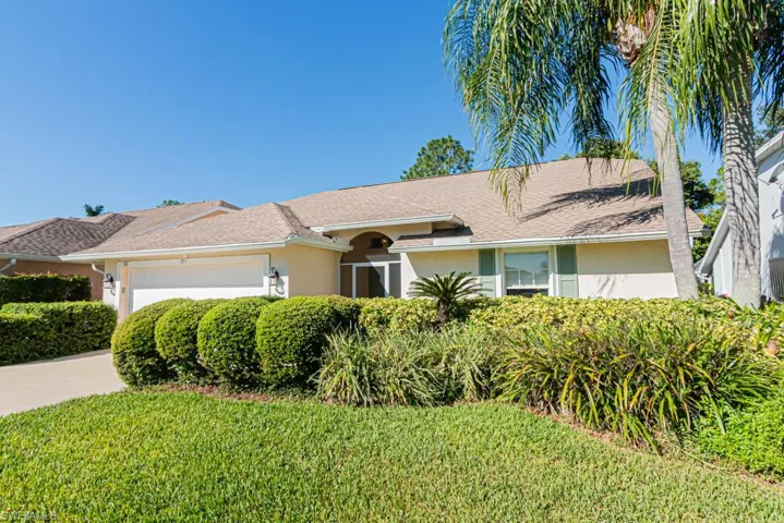Ranch-style house featuring stucco siding, a garage, driveway, a shingled roof, and a front lawn
