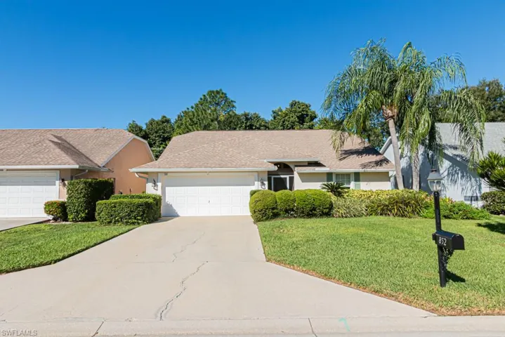 Ranch-style home featuring a front lawn, stucco siding, concrete driveway, and an attached garage