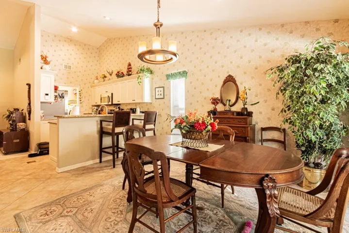 Dining space featuring light tile patterned flooring and a chandelier