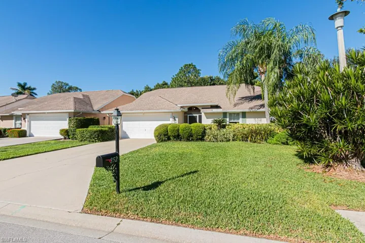 Ranch-style house with a front lawn, concrete driveway, an attached garage, and stucco siding