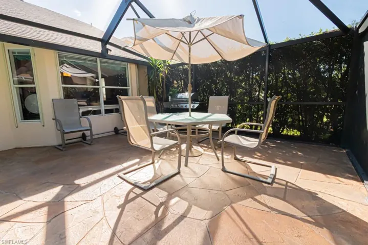 View of patio with glass enclosure, a sunroom, and outdoor dining area
