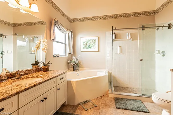 Bathroom featuring a bath, vanity, a shower stall, and light tile patterned floors