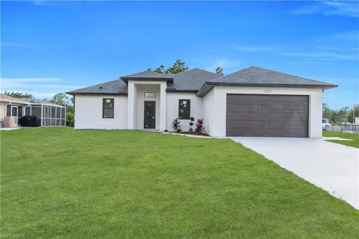 Prairie-style house featuring stucco siding, a front yard, concrete driveway, roof with shingles, and a garage