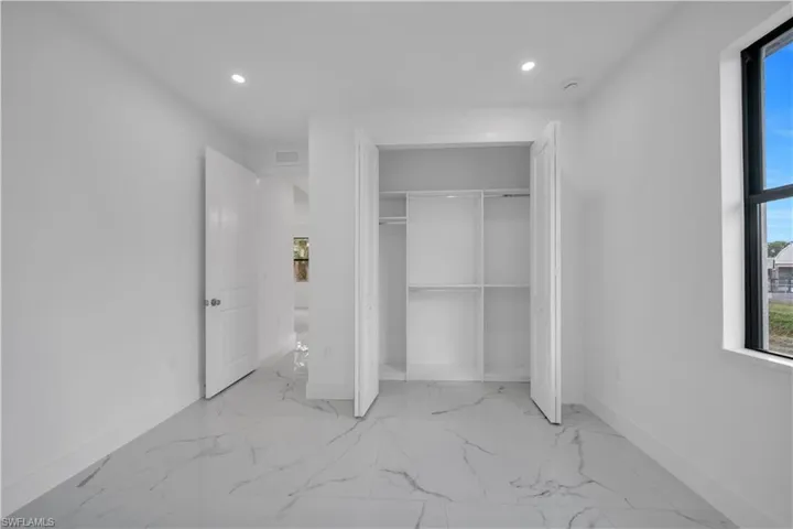 Unfurnished bedroom with light marble finish floors, recessed lighting, and a closet