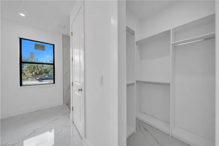 Walk in closet with light marble finish floors