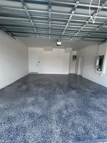 Garage with electric panel and a textured wall