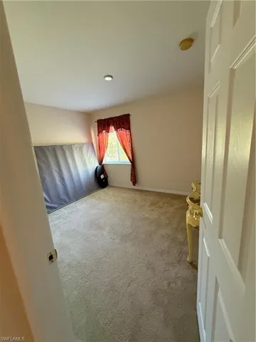 Empty room with baseboards and carpet floors