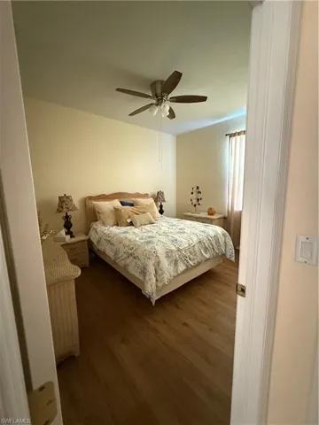 Bedroom with dark wood-style floors and ceiling fan