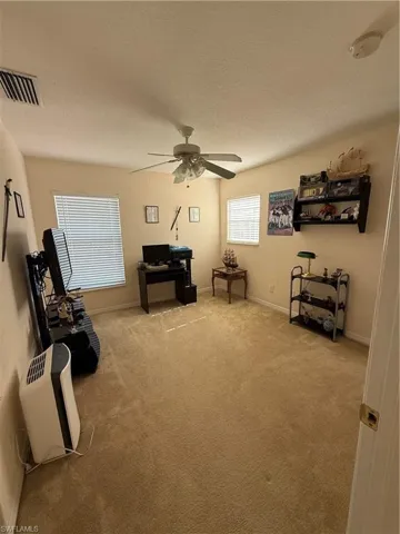 Sitting room with visible vents, baseboards, ceiling fan, carpet, and a textured ceiling