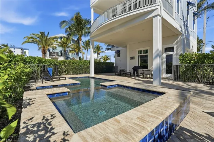 View of swimming pool featuring a hot tub, a patio, a balcony, and outdoor dining area