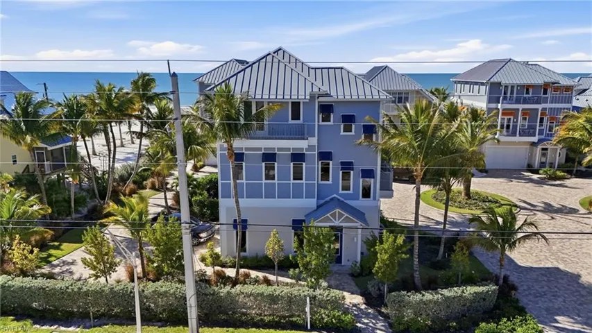 View of front of property with stucco siding, a water view, and decorative driveway