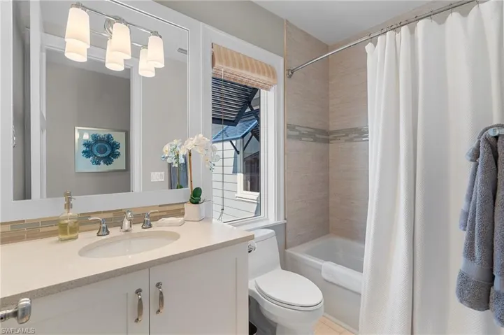 Bathroom with shower / bath combo, toilet, and vanity