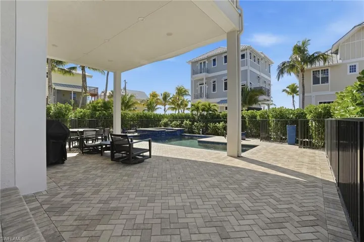 Fenced backyard featuring a patio, a pool with connected hot tub, outdoor dining space, and a grill