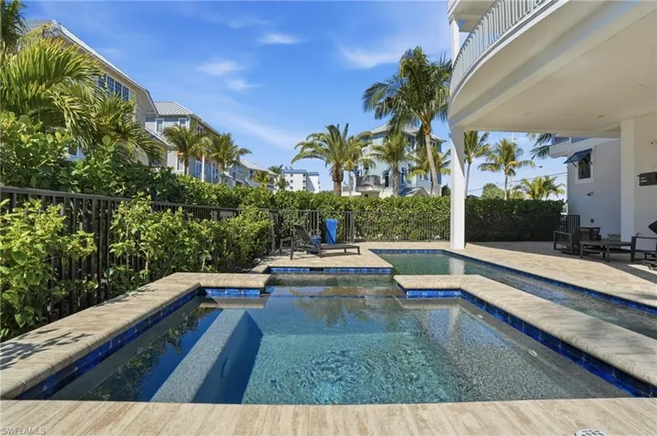 View of pool with a patio area, a fenced backyard, a balcony, and a pool with connected hot tub