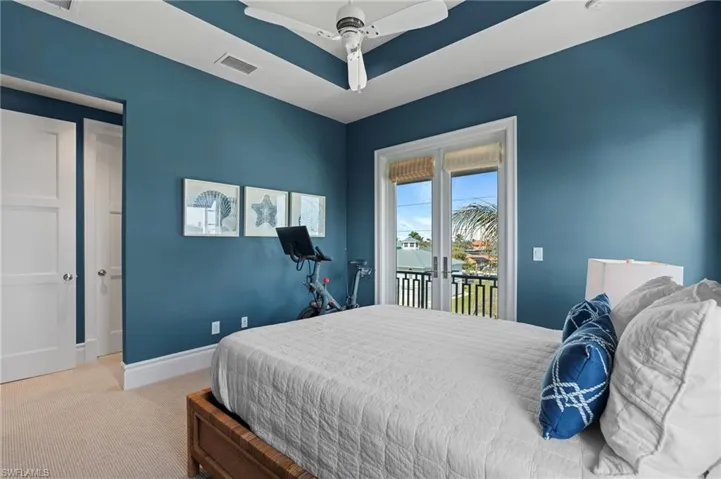 Bedroom with visible vents, baseboards, a raised ceiling, carpet, and access to outside