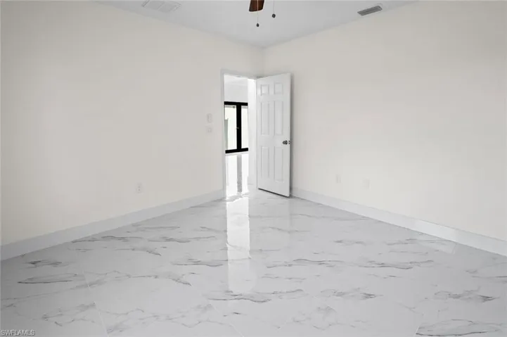 Unfurnished room featuring ceiling fan and light tile floors