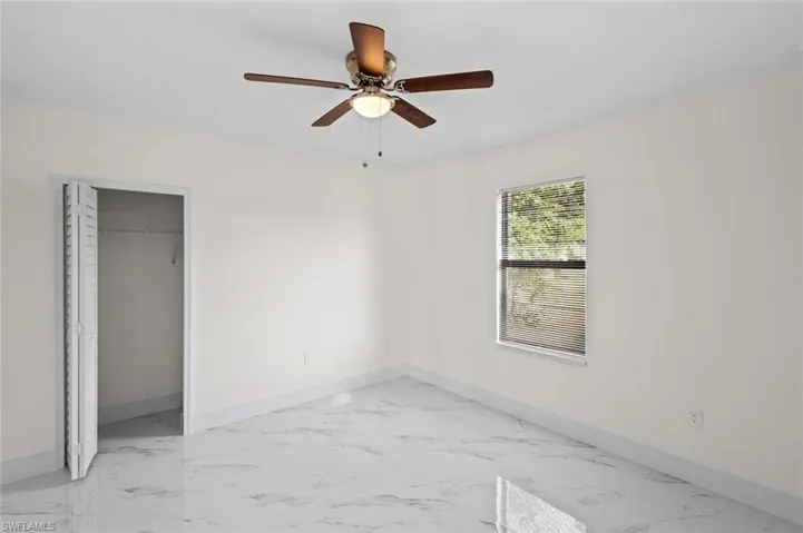 Unfurnished bedroom featuring a closet, ceiling fan, and light tile floors