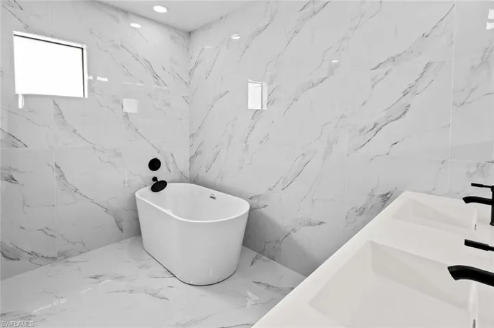 Bathroom with tile walls and a bath