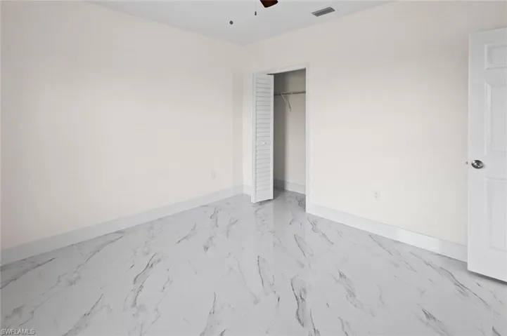 Unfurnished bedroom with a closet, ceiling fan, and light tile floors