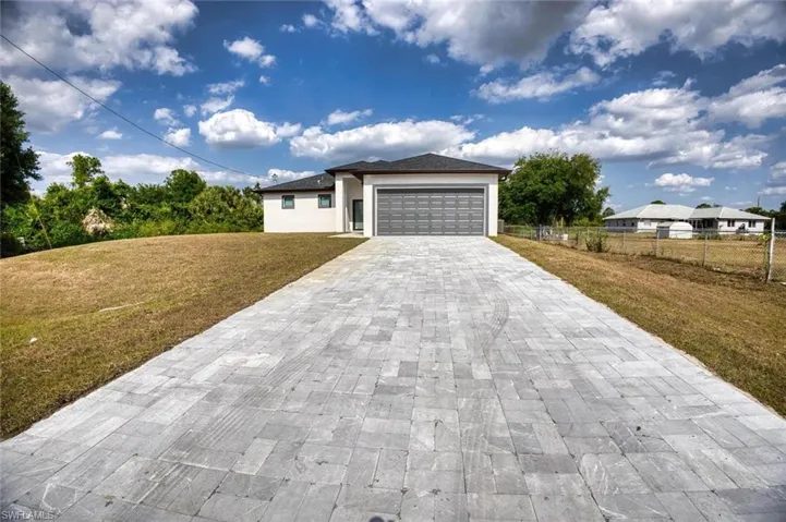 View of front of property featuring a garage and a front yard