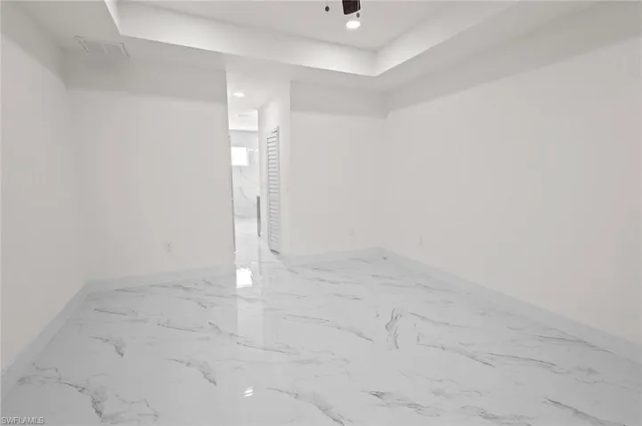 Tiled spare room with a tray ceiling