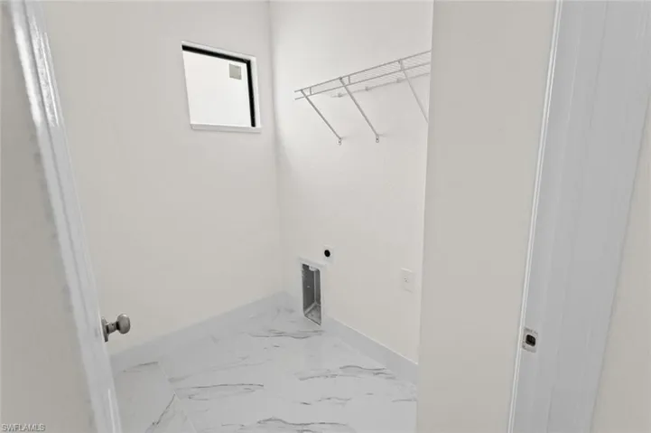 Laundry room featuring tile flooring and hookup for an electric dryer