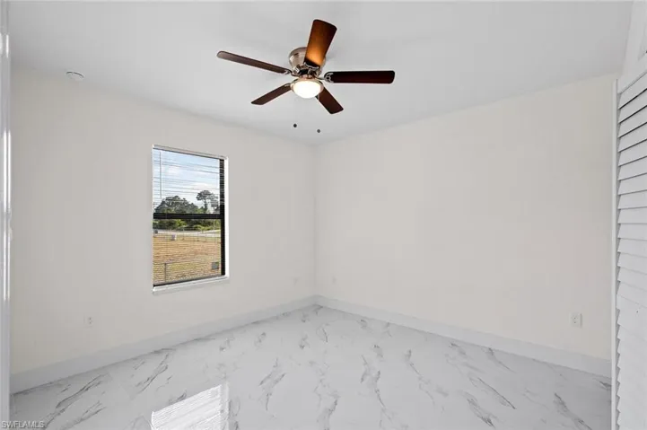 Tiled empty room featuring ceiling fan