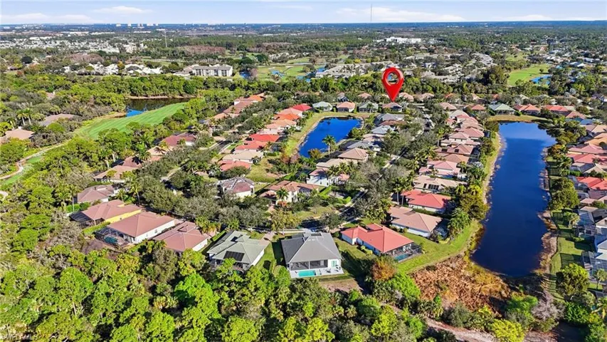 Aerial view of property and surrounding area with nearby suburban area and a large body of water