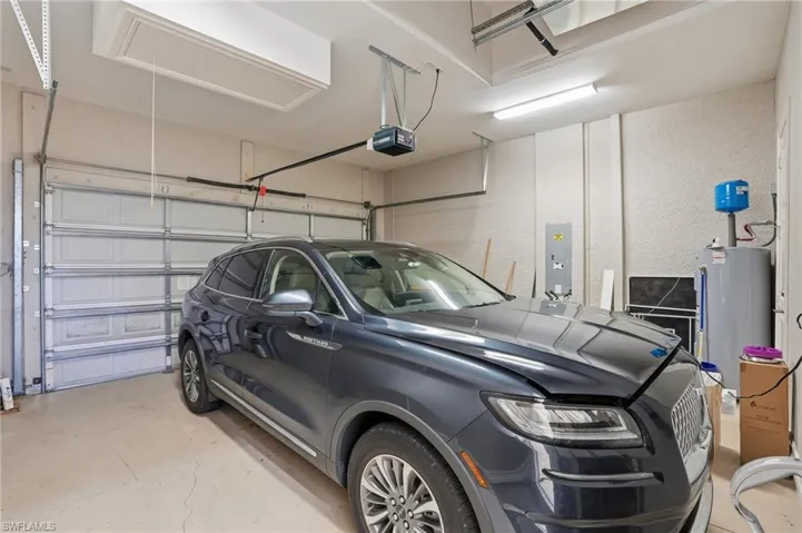 Garage features high ceilings and a separate storage closet