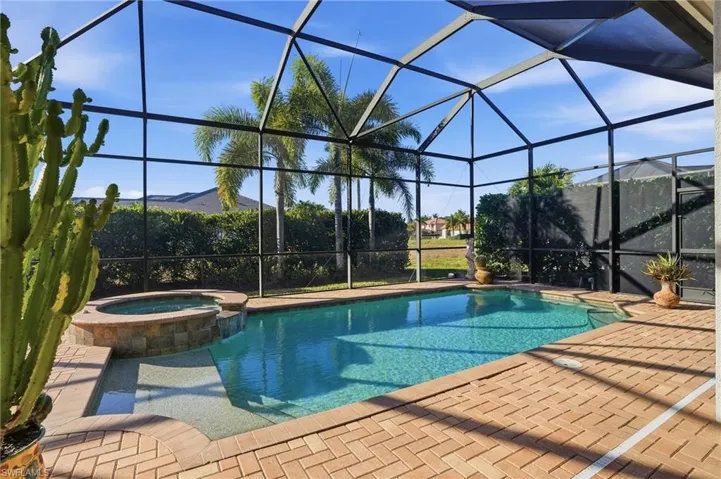 Combined pool / hot tub with a sunroom, a lanai, and a patio area