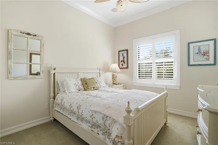 Carpeted bedroom with crown molding and a ceiling fan