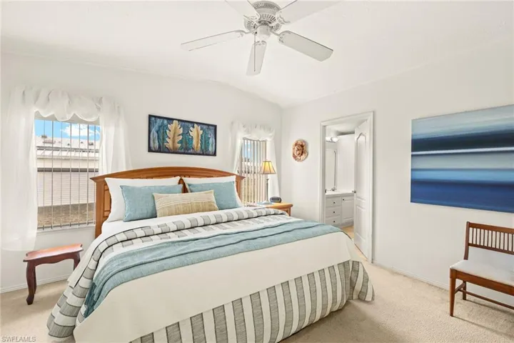 Bedroom with lofted ceiling, baseboards, and carpet floors
