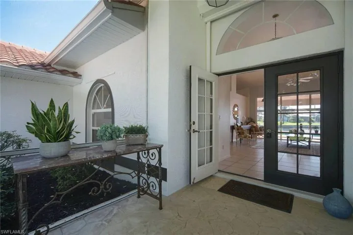View of exterior entry with French doors, a tile roof, and stucco siding.  Double door entrance with glass doors.