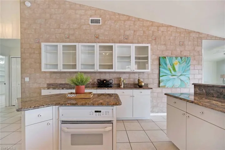 Kitchen with wonderful island and tasteful granite. Glass door cabinets for showing off your china and glassware.
