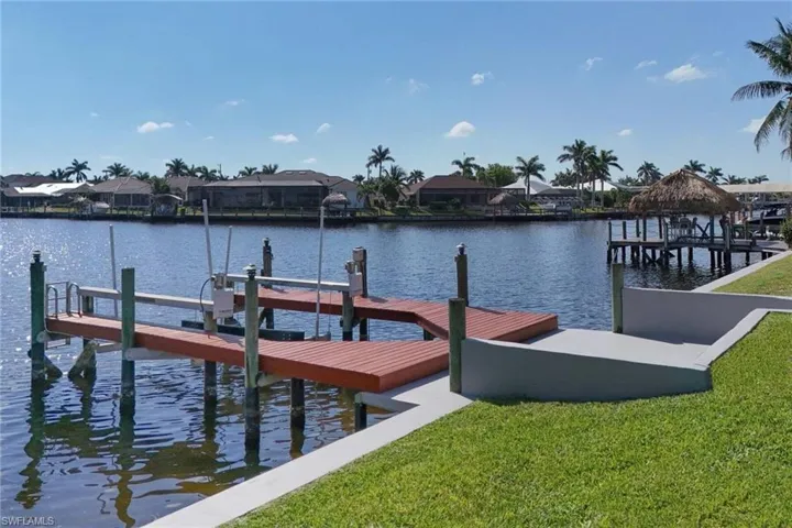 View of dock featuring boat lift, a residential view, and a water view