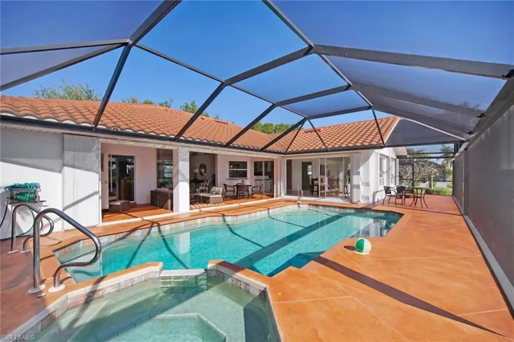 View of pool with outdoor lounge area, a pool with connected hot tub, and a patio
