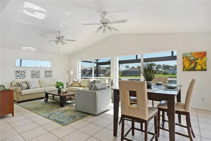 Living area featuring plenty of natural light, a ceiling fan, and light tile patterned floors.  This beautiful family room has a full view of the water and the fish jumping.  It opens up to the pool.