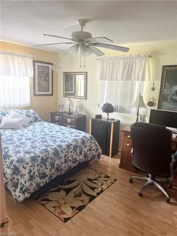 Bedroom featuring wood finished floors, a textured ceiling, and ceiling fan