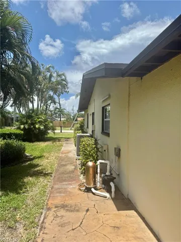 View of side of home with stucco siding and central AC