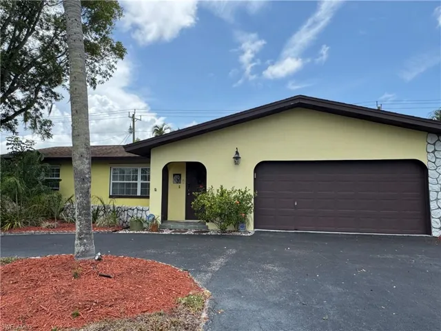 View of front of home with stucco siding, asphalt driveway, and an attached garage