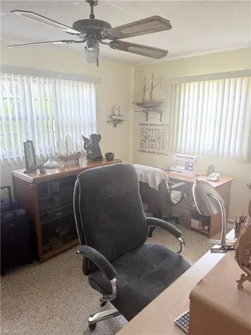 Office area with speckle patterned floor, ceiling fan, plenty of natural light, and a textured ceiling