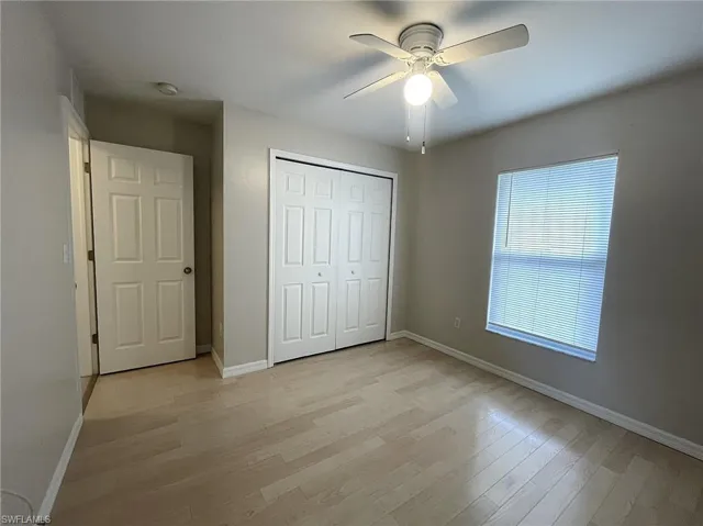 Unfurnished bedroom featuring a closet, light wood-type flooring, and ceiling fan