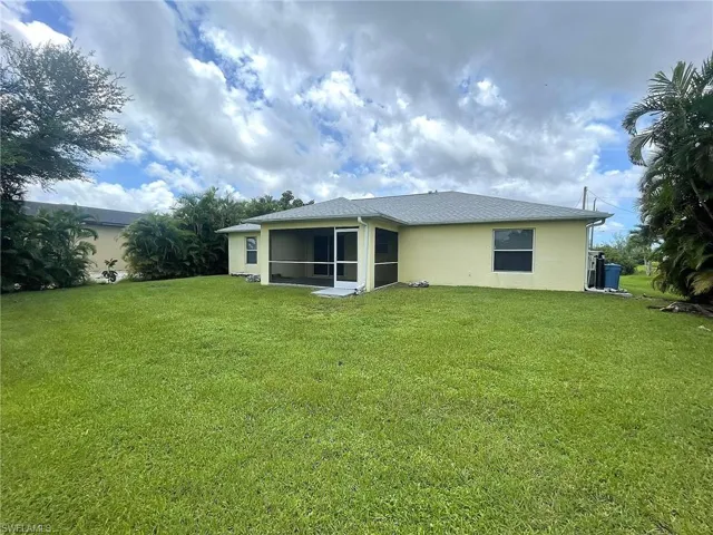 Rear view of house featuring a yard