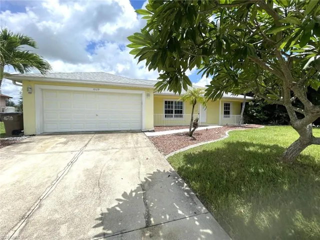 Ranch-style house with a garage and a front lawn